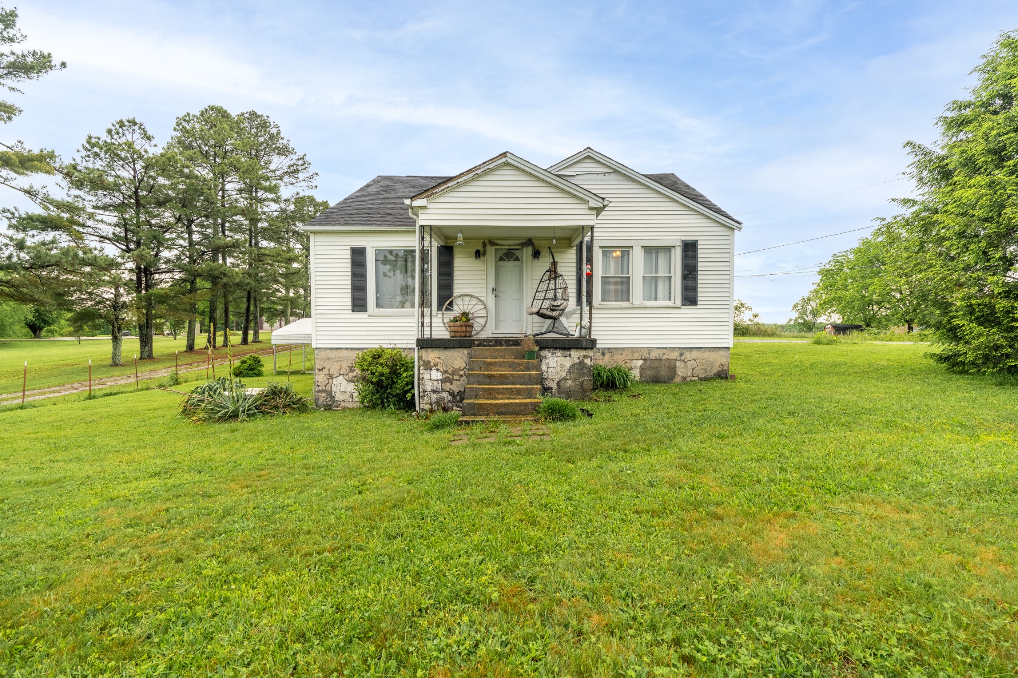 a front view of a house with a garden and trees