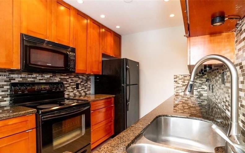 a kitchen with granite countertop a stove and a microwave