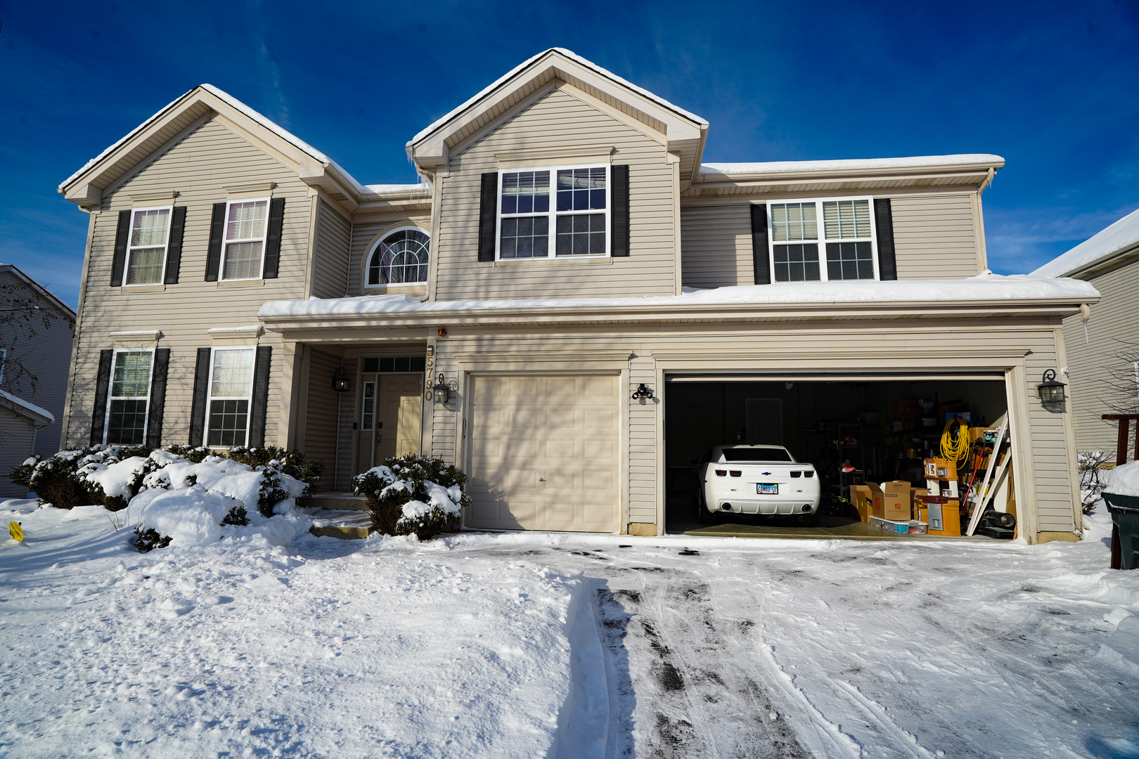 a front view of a house with cars