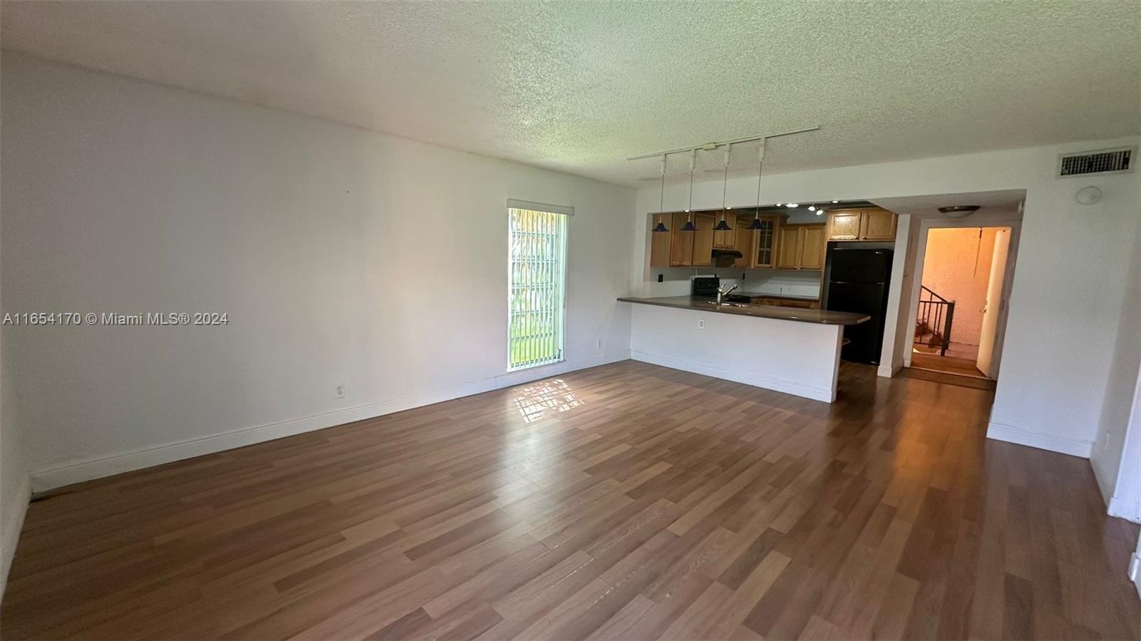 a view of kitchen and hall with wooden floor