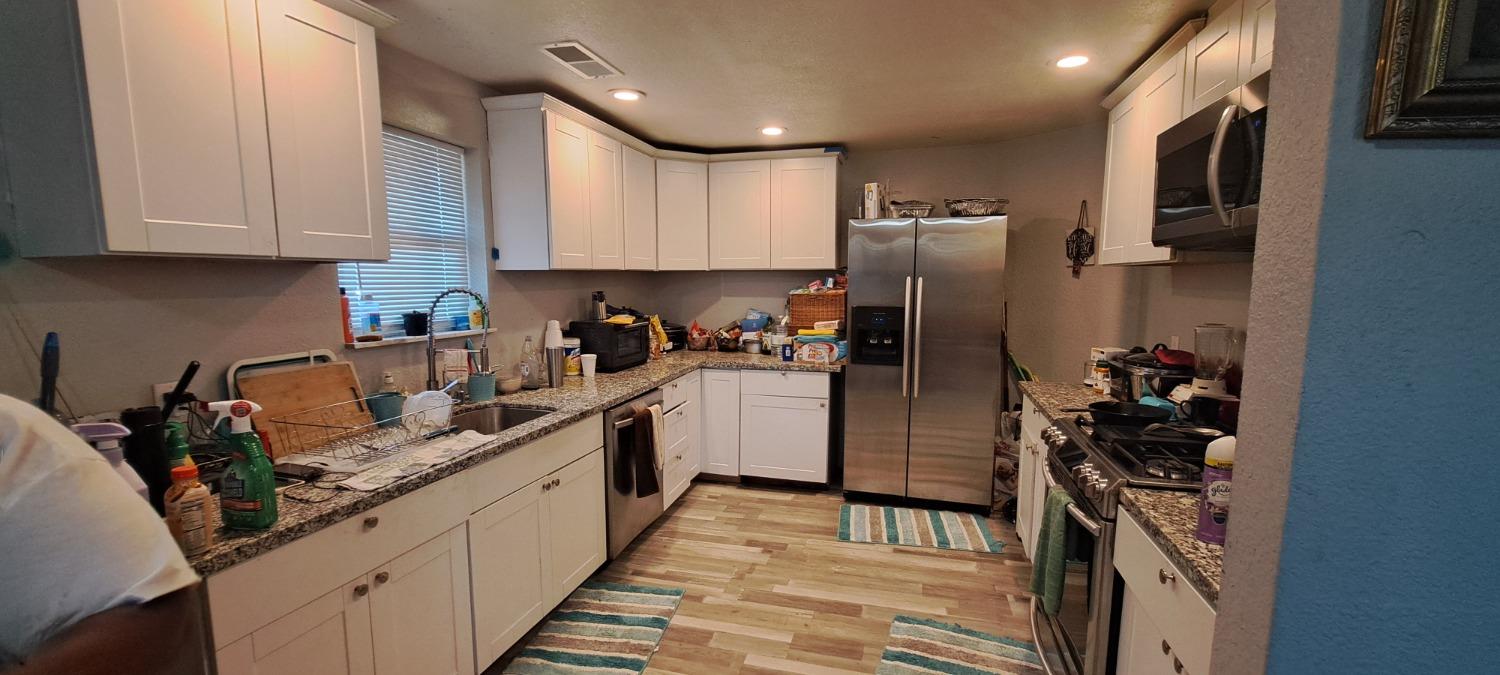 a kitchen with stainless steel appliances granite countertop a refrigerator sink and cabinets