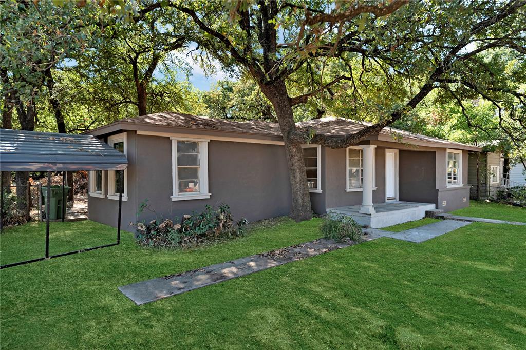 a front view of a house with a garden and yard