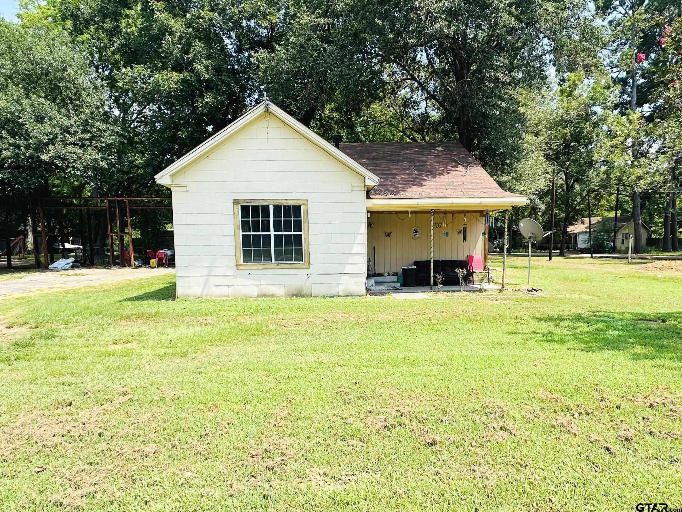 a view of a house with a yard and sitting area