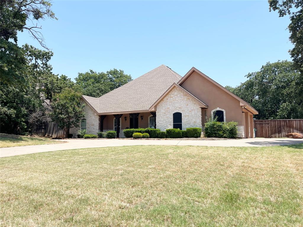 a front view of house with yard and trees in the background