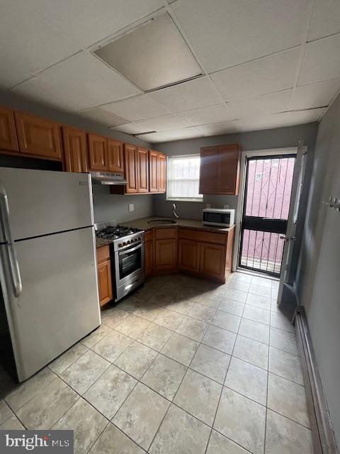 a kitchen with granite countertop a stove a sink and a refrigerator