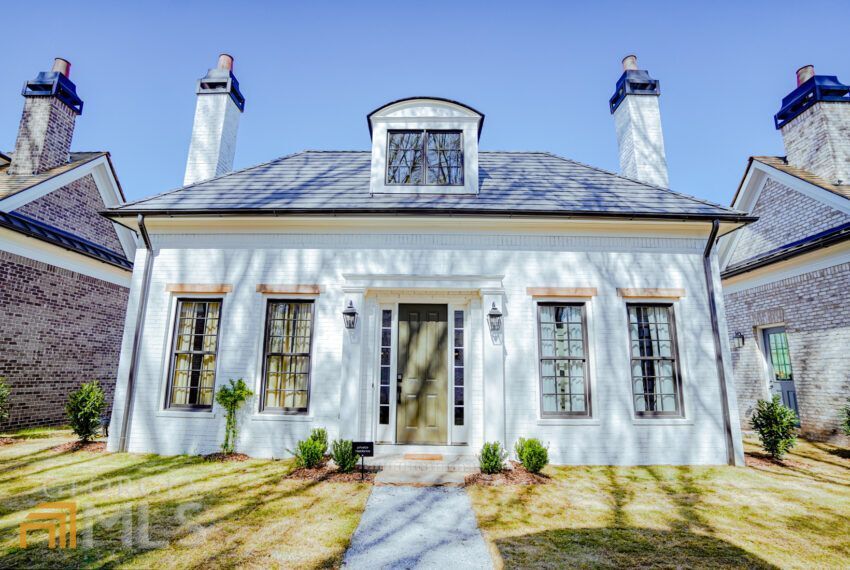 a view of a house with large windows and plants