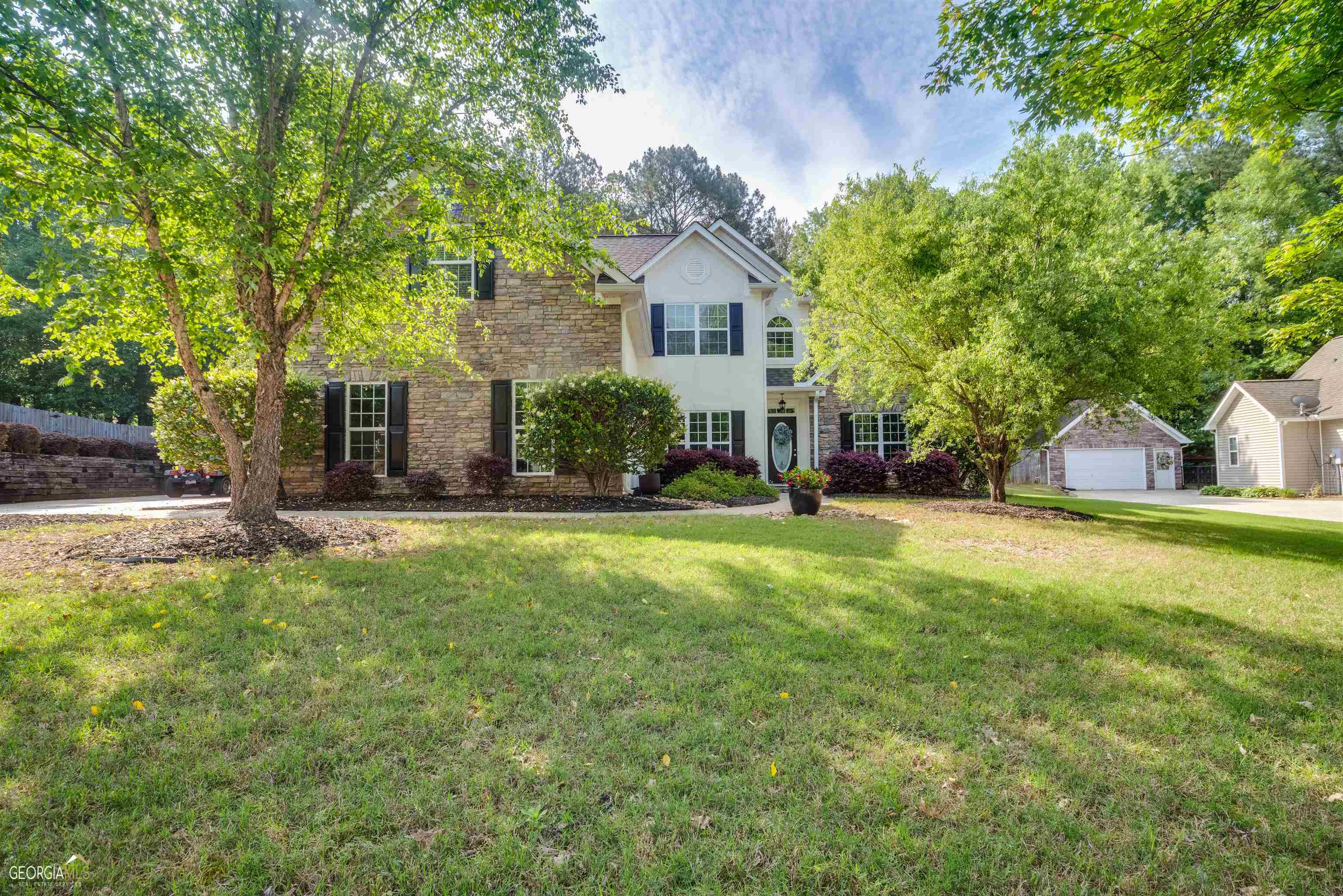 a front view of a house with a yard and trees