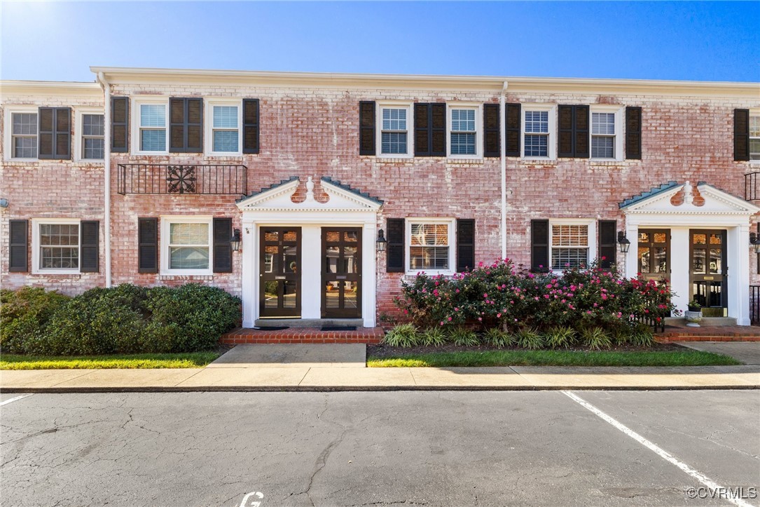 front view of a brick house with a yard