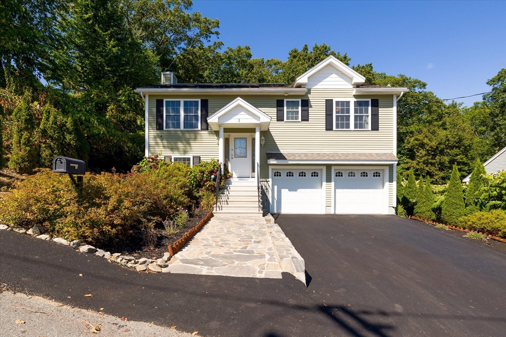 a front view of a house with a yard and a garage