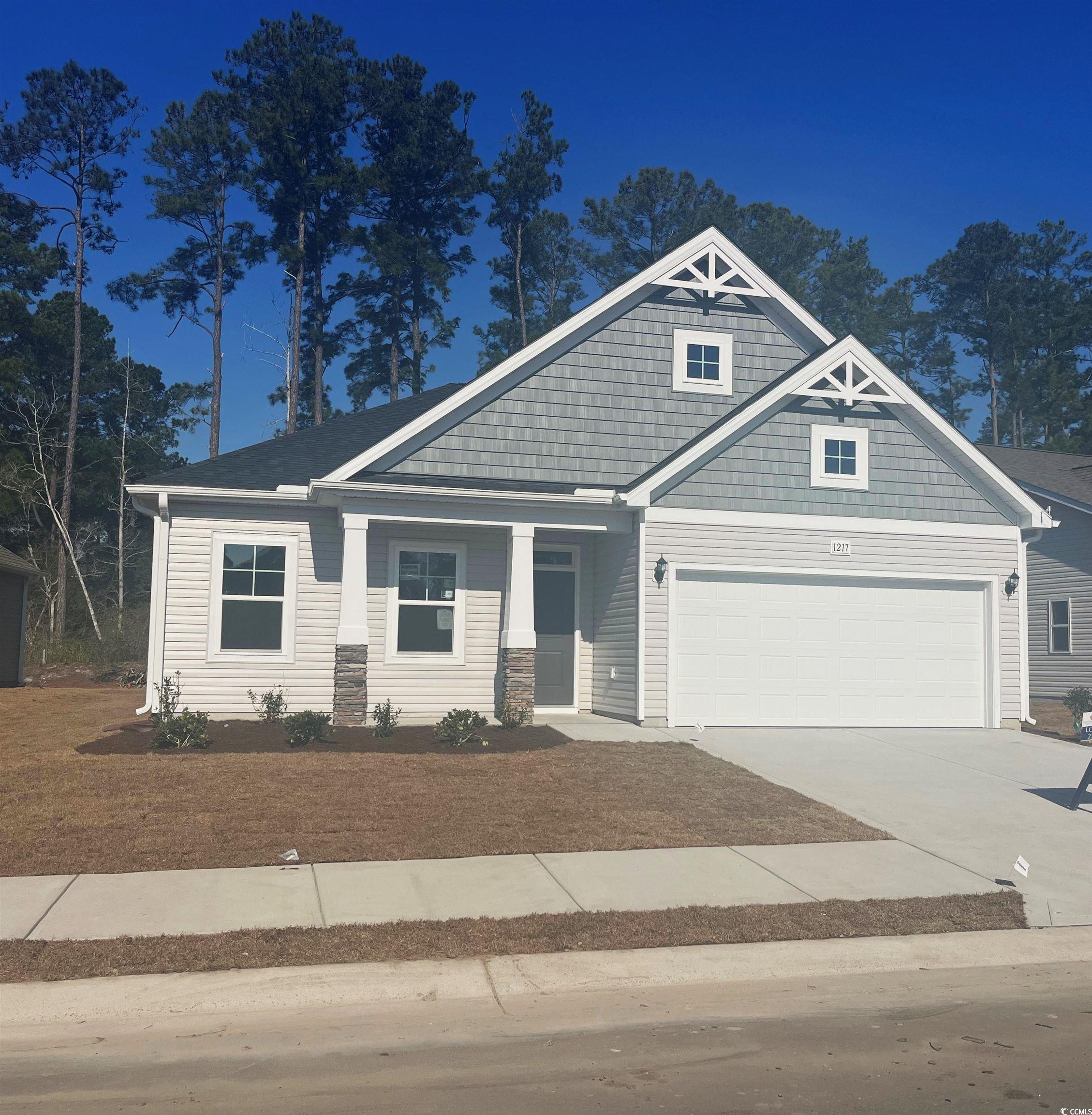 Craftsman-style home featuring driveway and a gara