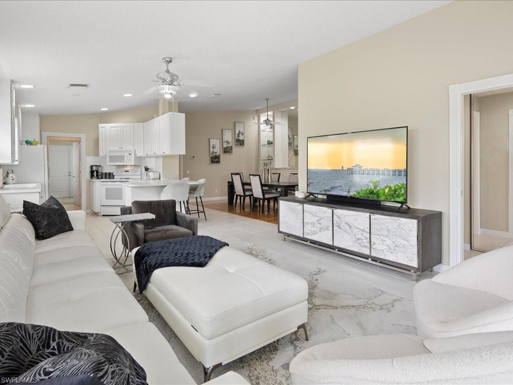 Living room with ceiling fan and light hardwood / wood-style flooring