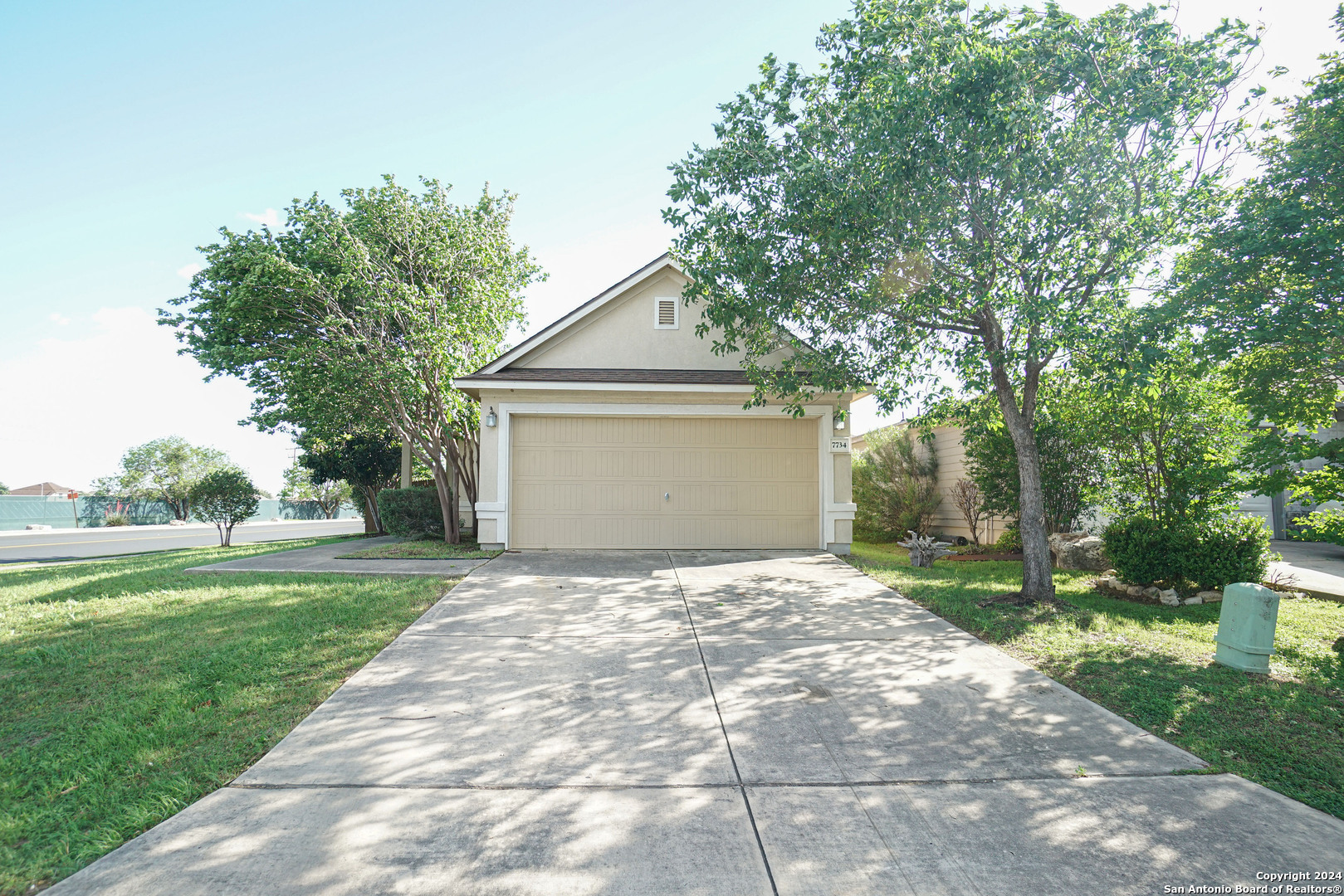 a front view of a house with a yard and trees