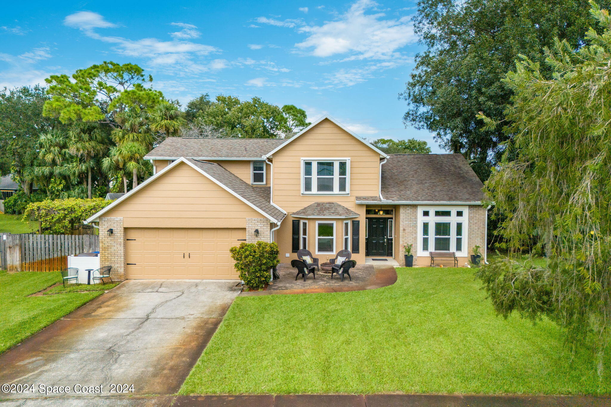 a front view of a house with a yard and green space