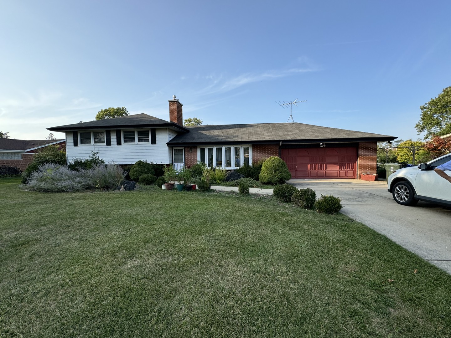 a front view of a house with a garden and plants