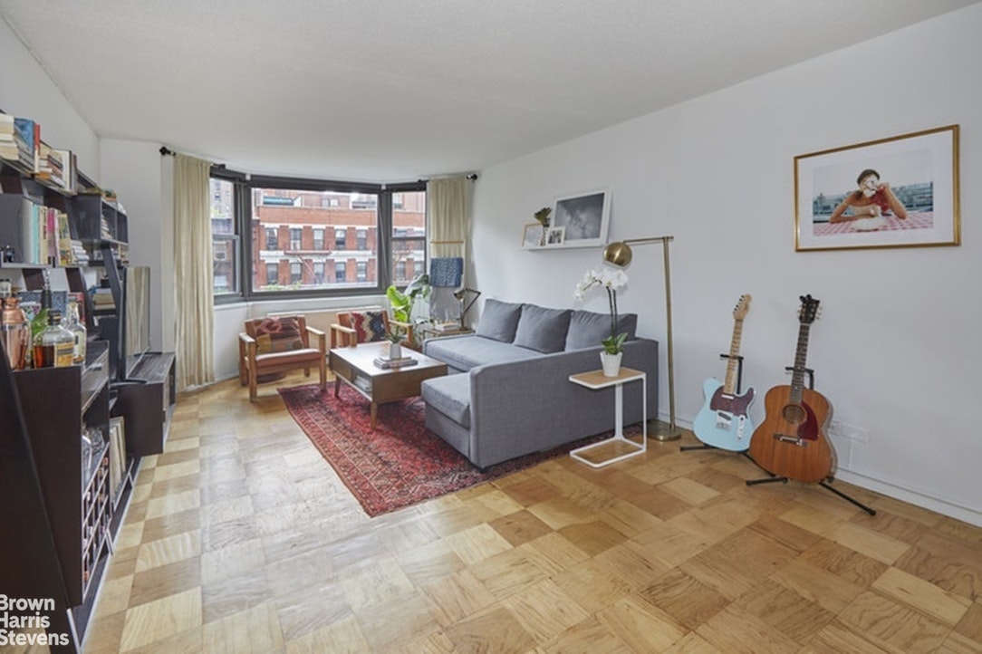 a living room with furniture a window and a flat screen tv