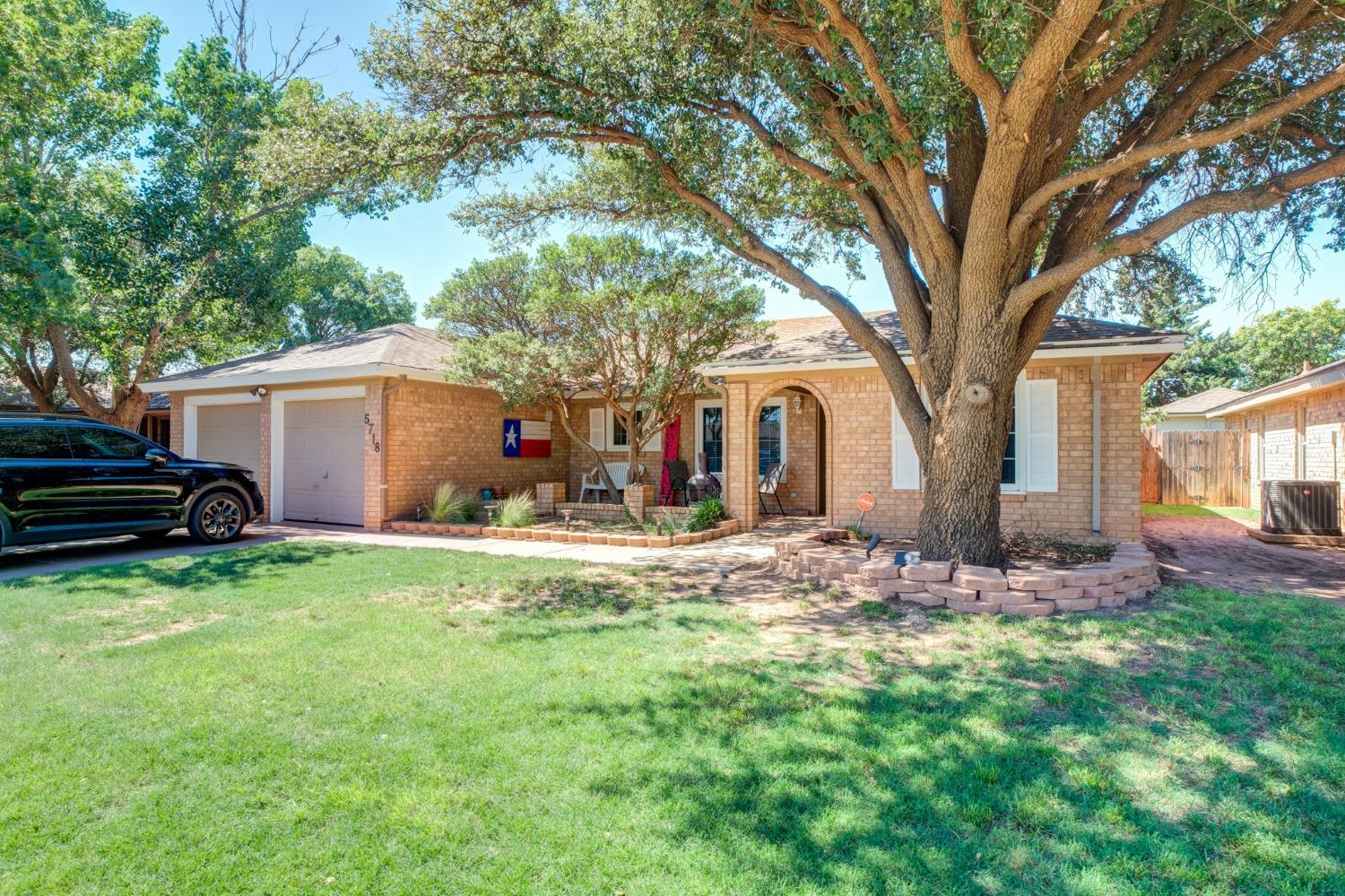 a view of a house with backyard and tree