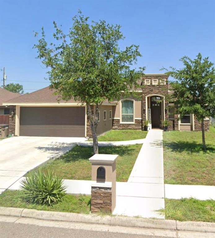 View of front of home featuring a garage and a front lawn