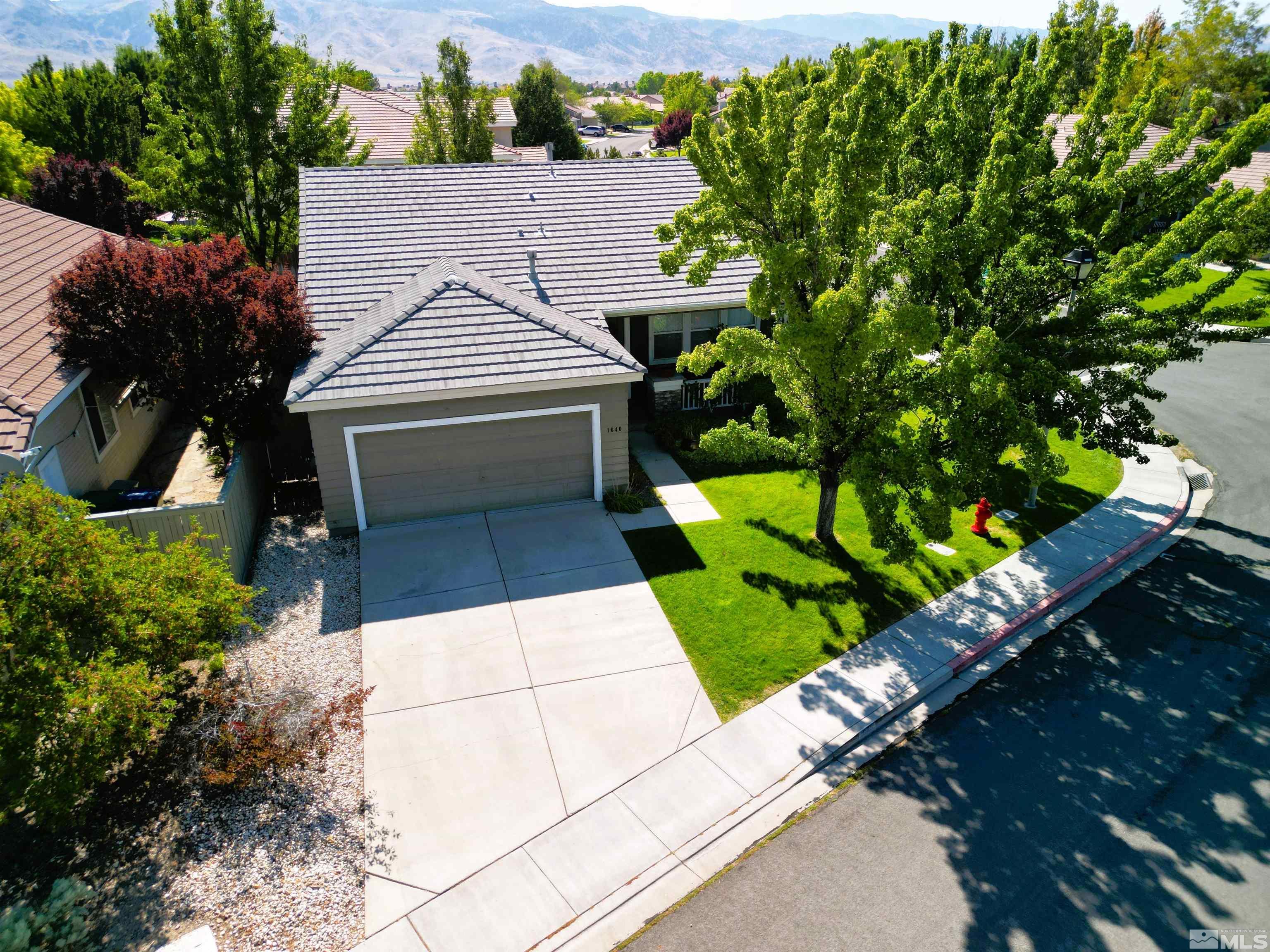 a aerial view of a house with a yard and potted plants