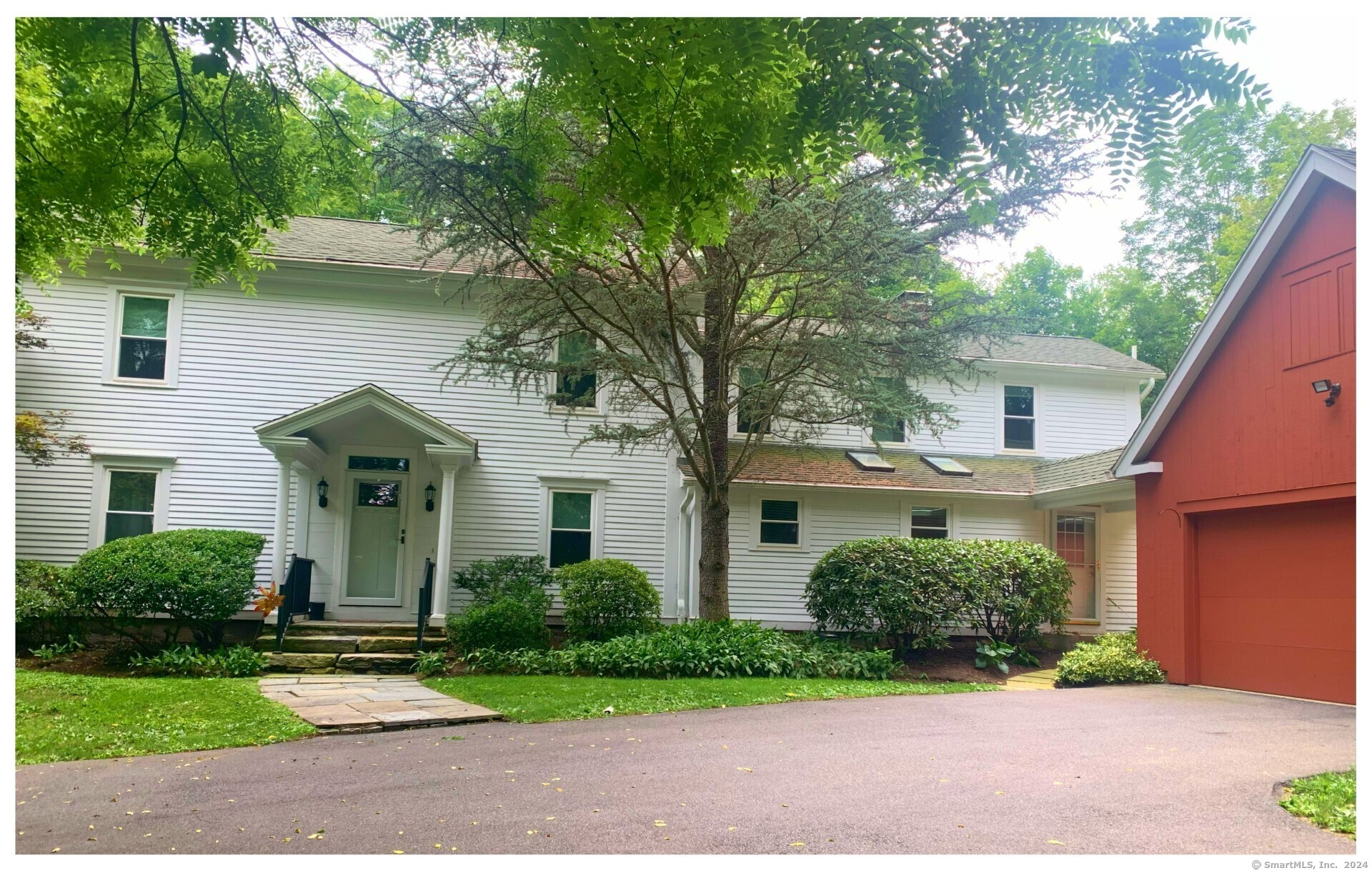 a front view of a house with a yard and potted plants