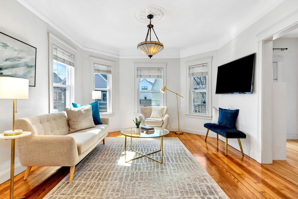 a living room with furniture a flat screen tv and a window