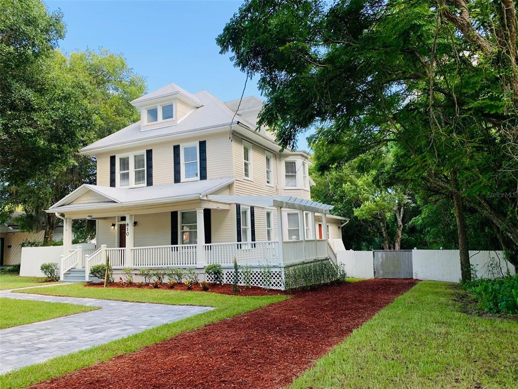 a front view of a house with a yard and trees