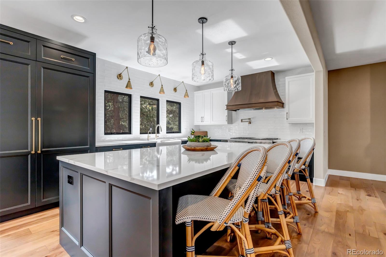 a kitchen with stainless steel appliances granite countertop a sink a stove and a refrigerator