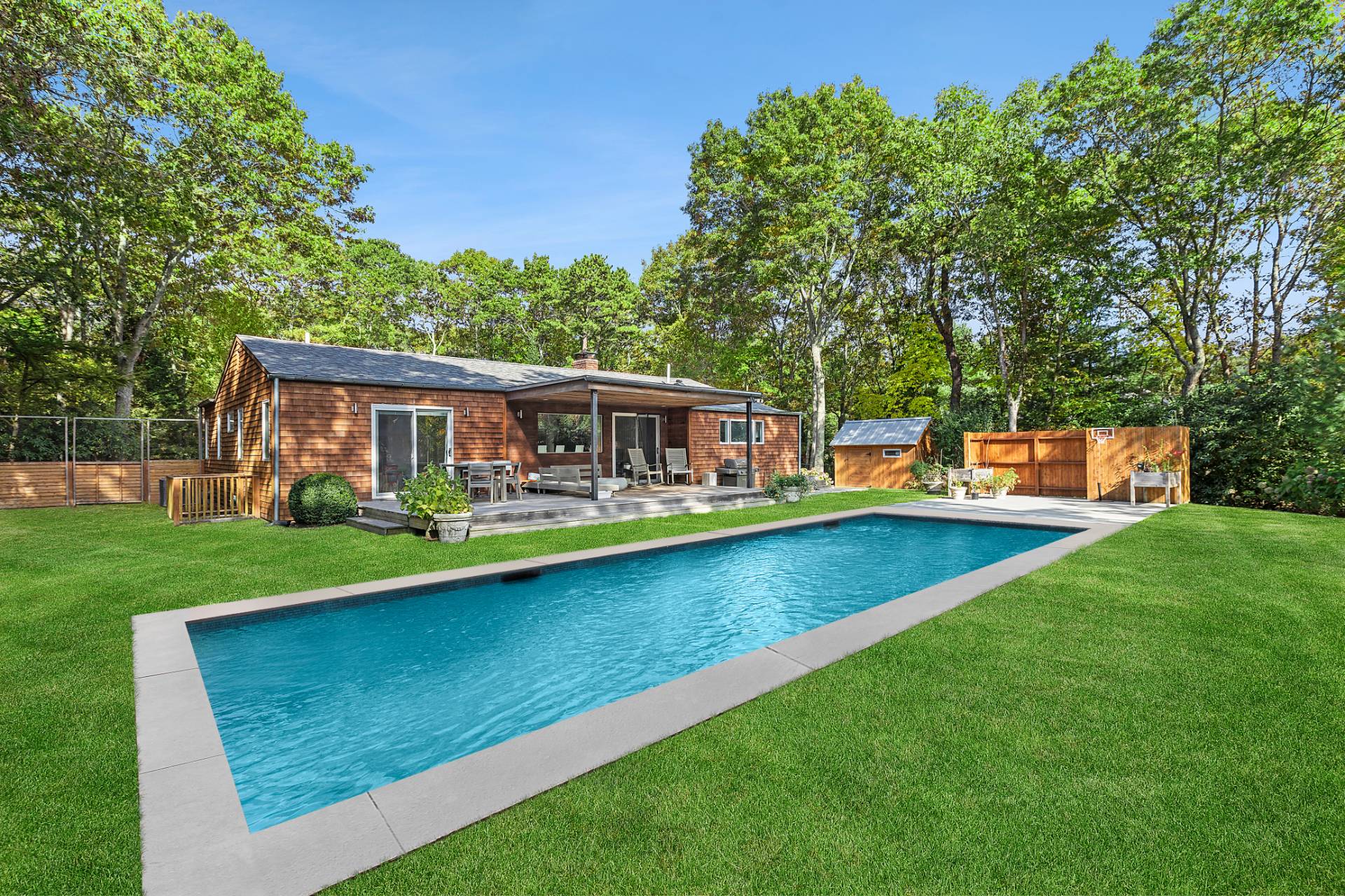 an outdoor view of house with garden space and swimming pool