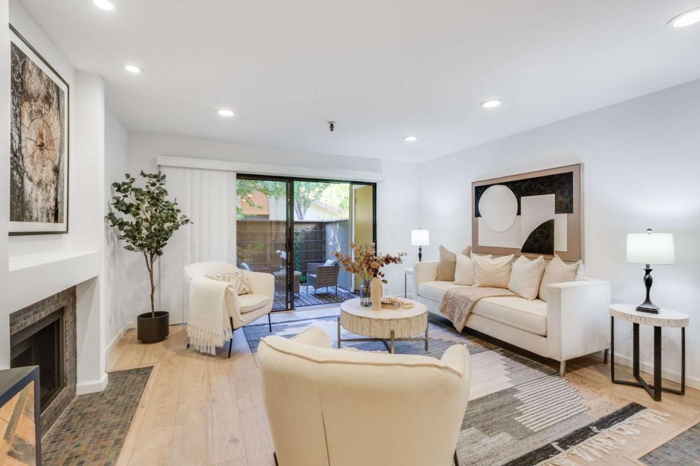 a living room with furniture a large window and a fireplace