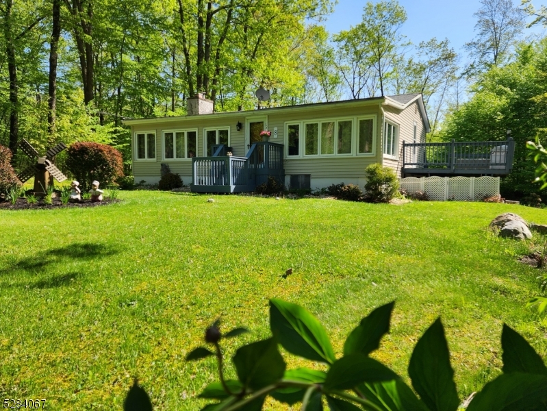 a view of house with backyard and outdoor seating