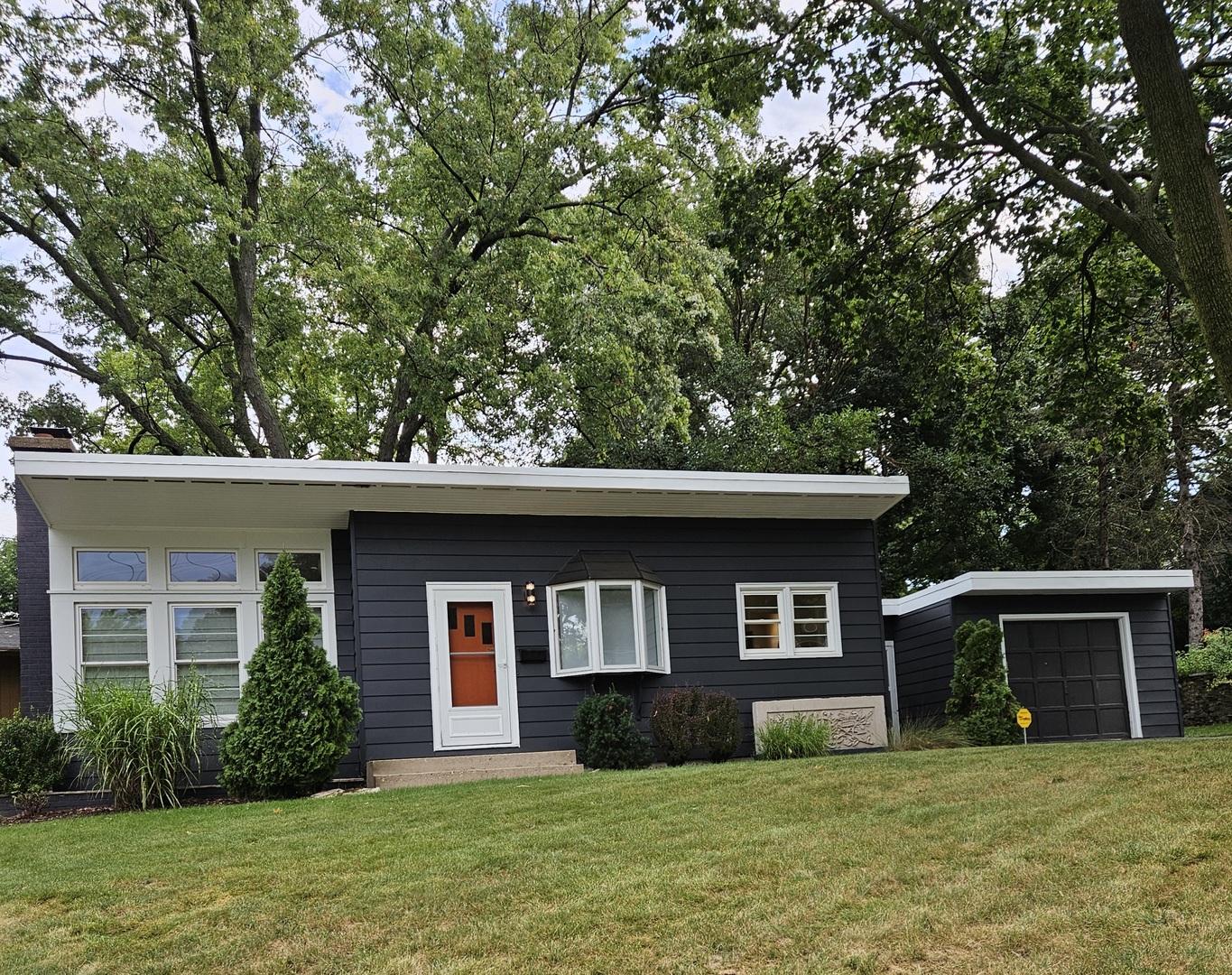 a front view of a house with yard and trees