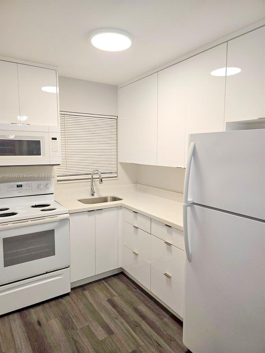 a kitchen with white cabinets and white appliances