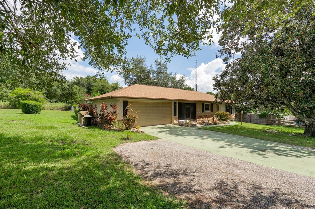 a view of a house with backyard and trees