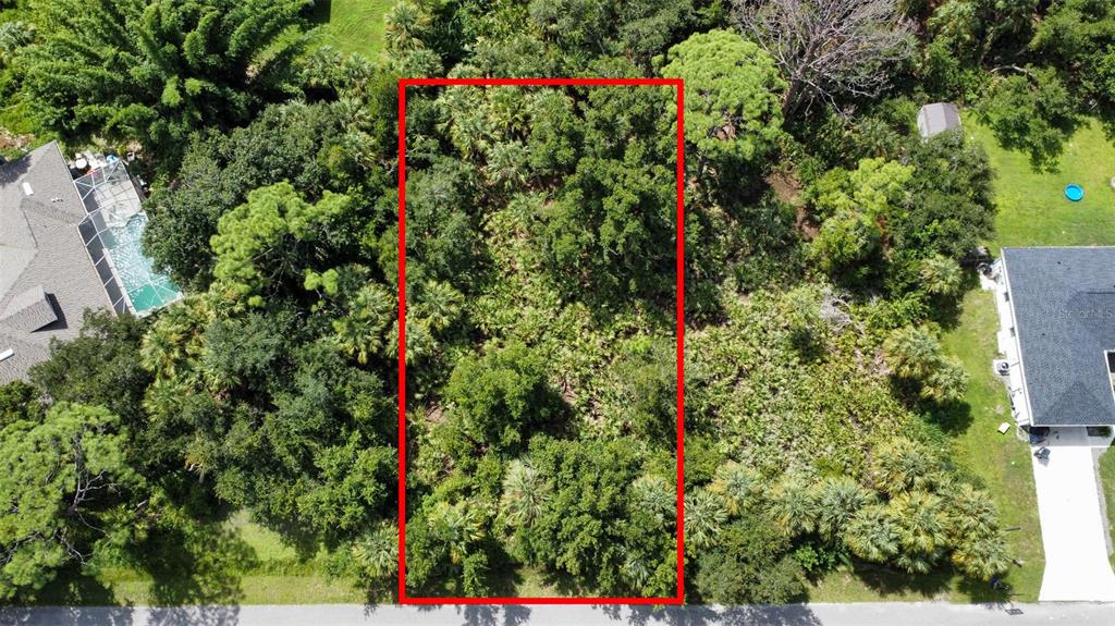 an aerial view of residential house with outdoor space and trees all around