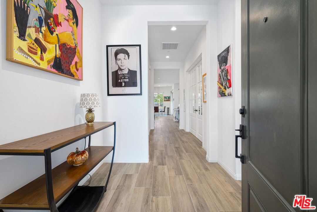 a view of a hallway with wooden floor and entryway