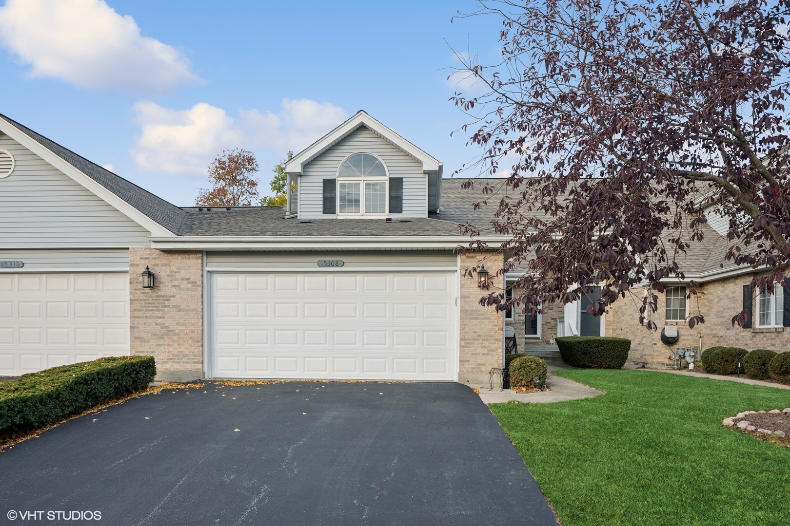 a front view of house with yard and garage