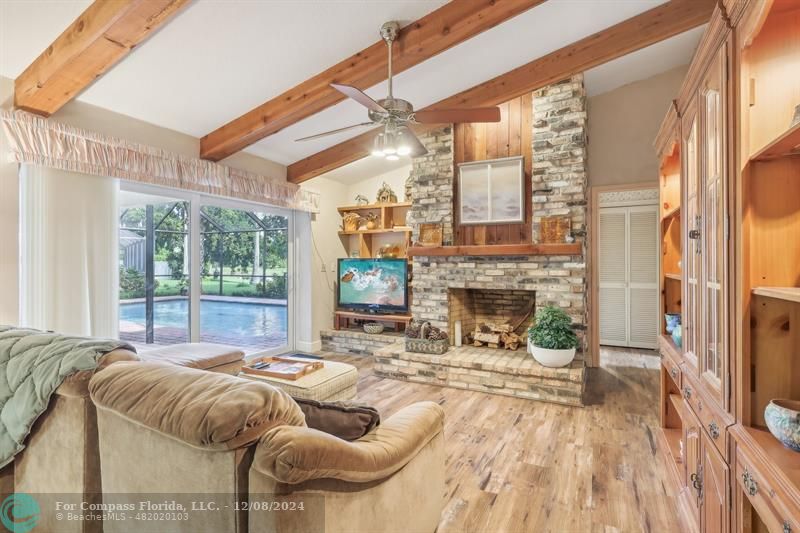 a living room with furniture a fireplace and a floor to ceiling window