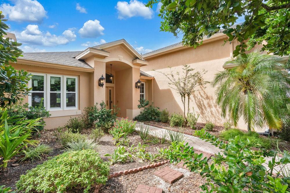 a front view of a house with a yard and potted plants