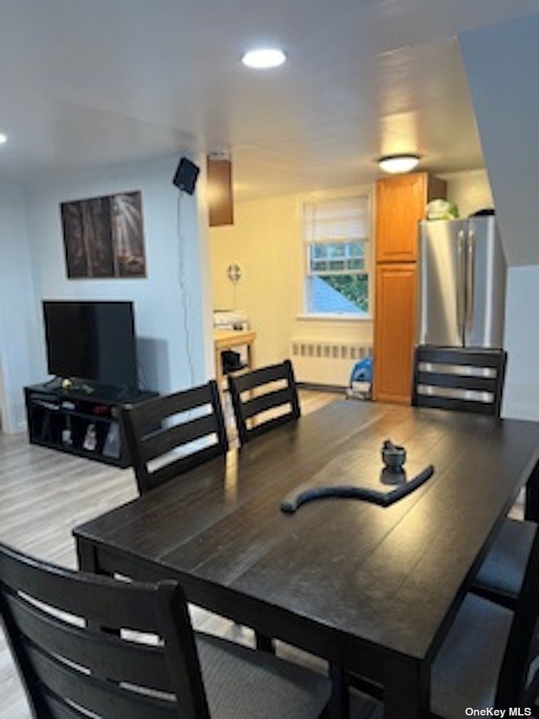 a living room with table chairs and a window