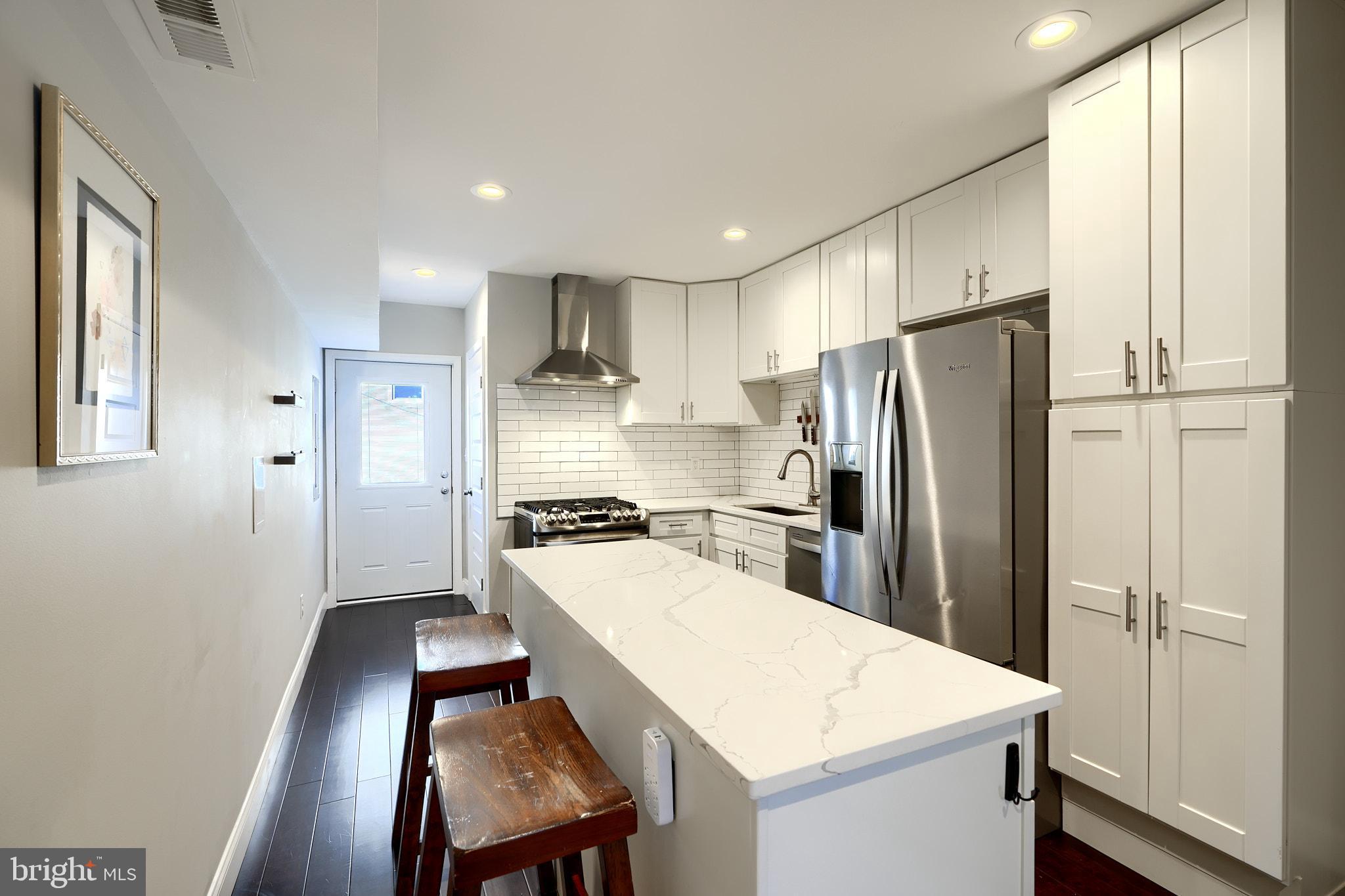 a kitchen with stainless steel appliances a refrigerator and a stove top oven