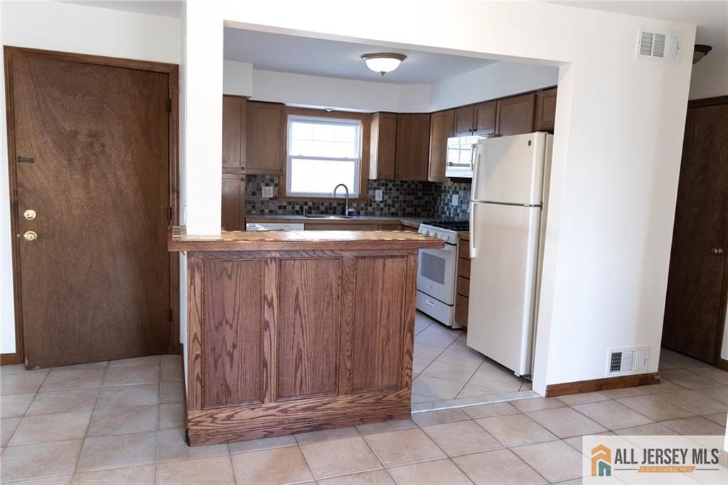 a kitchen with refrigerator and cabinets