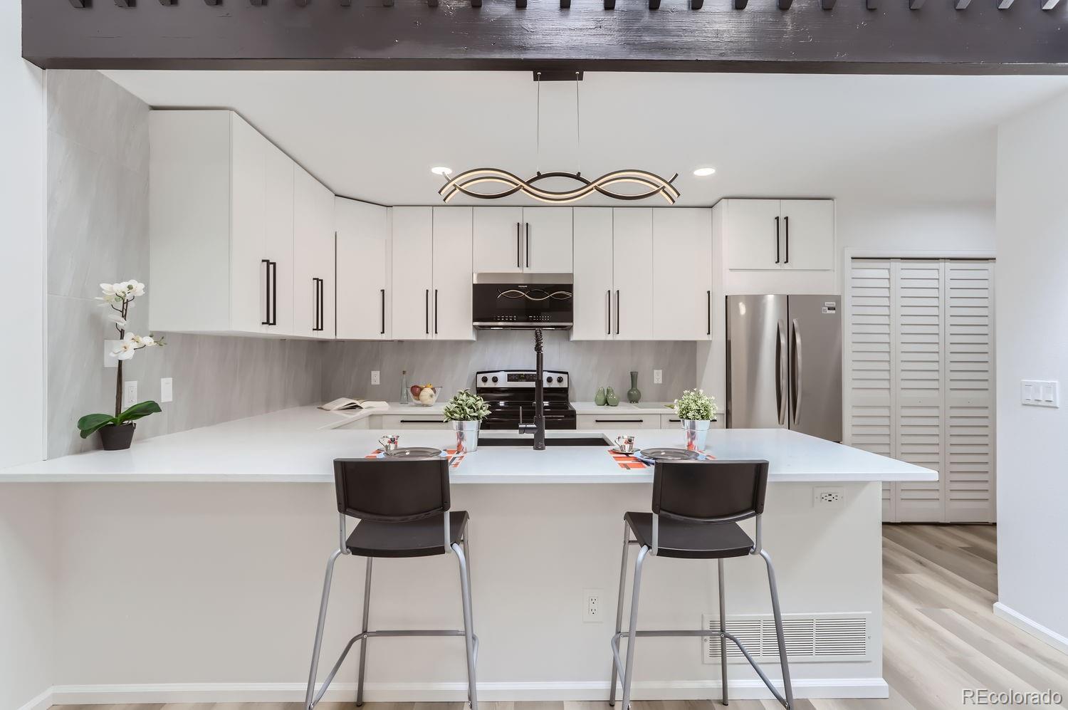 a kitchen with stainless steel appliances a table and chairs in it