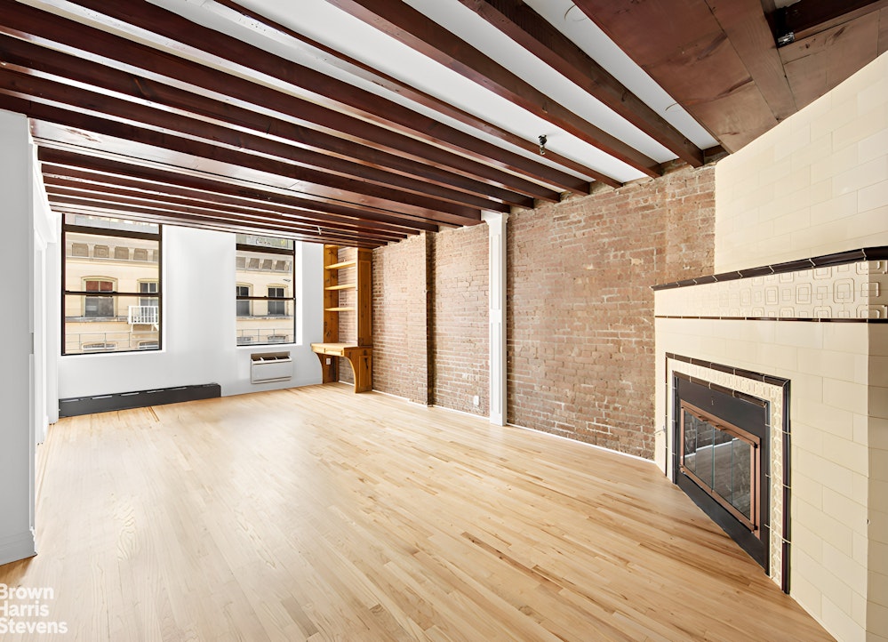 a view of an empty room with a fireplace and a window