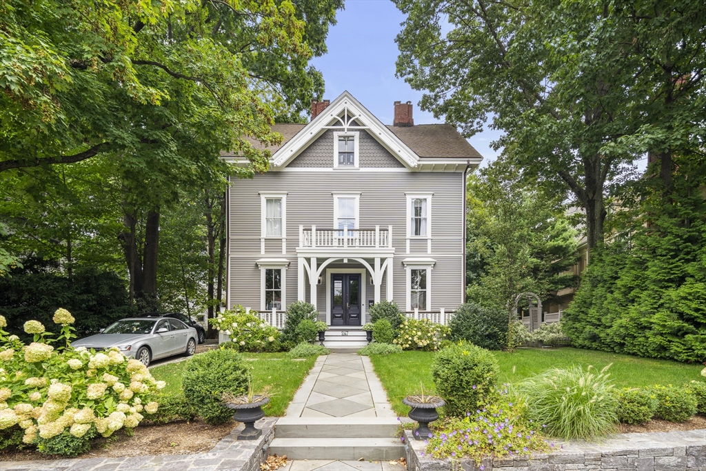 a front view of a house with a yard and potted plants