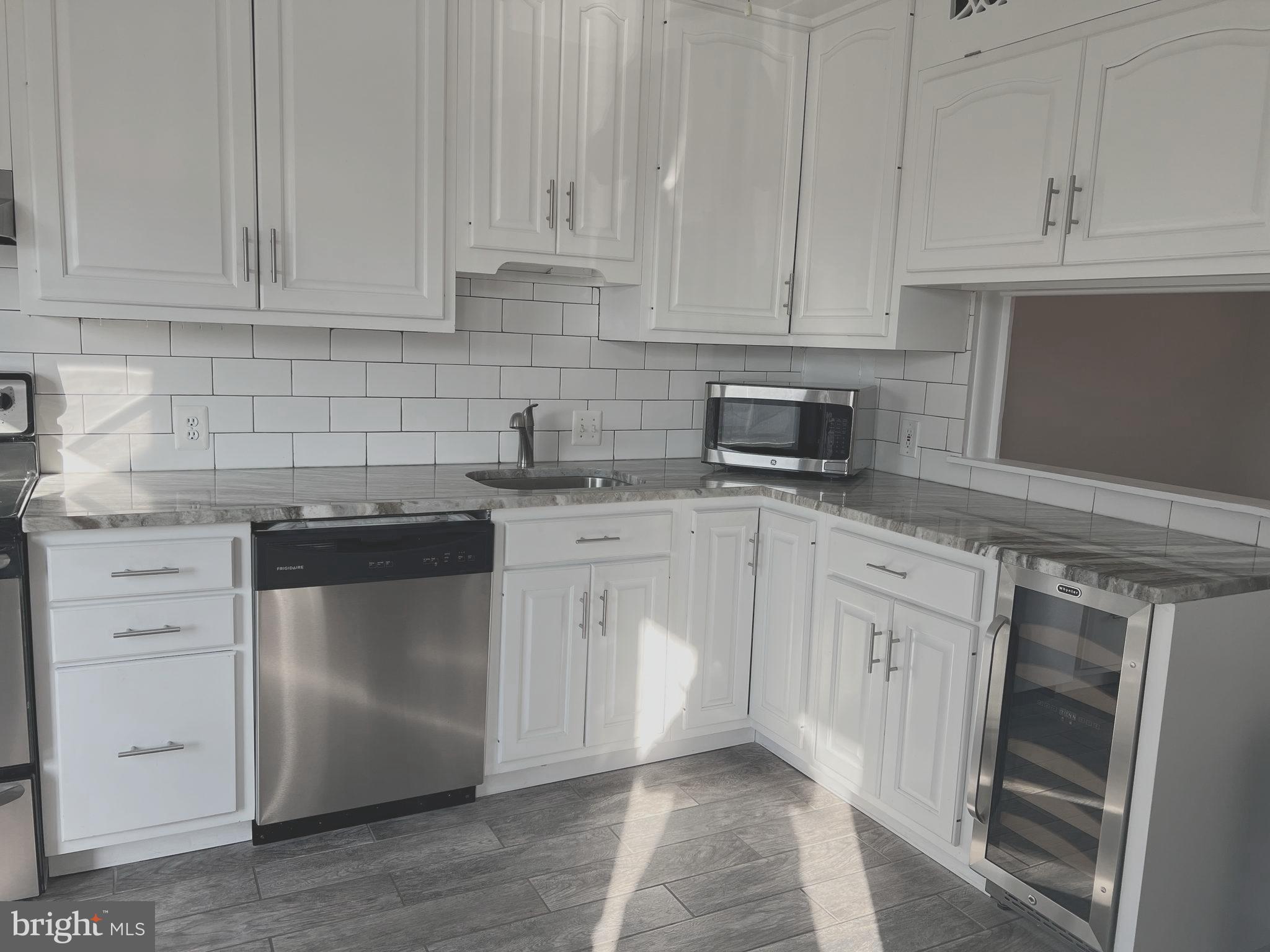 a kitchen with granite countertop white cabinets stainless steel appliances and sink