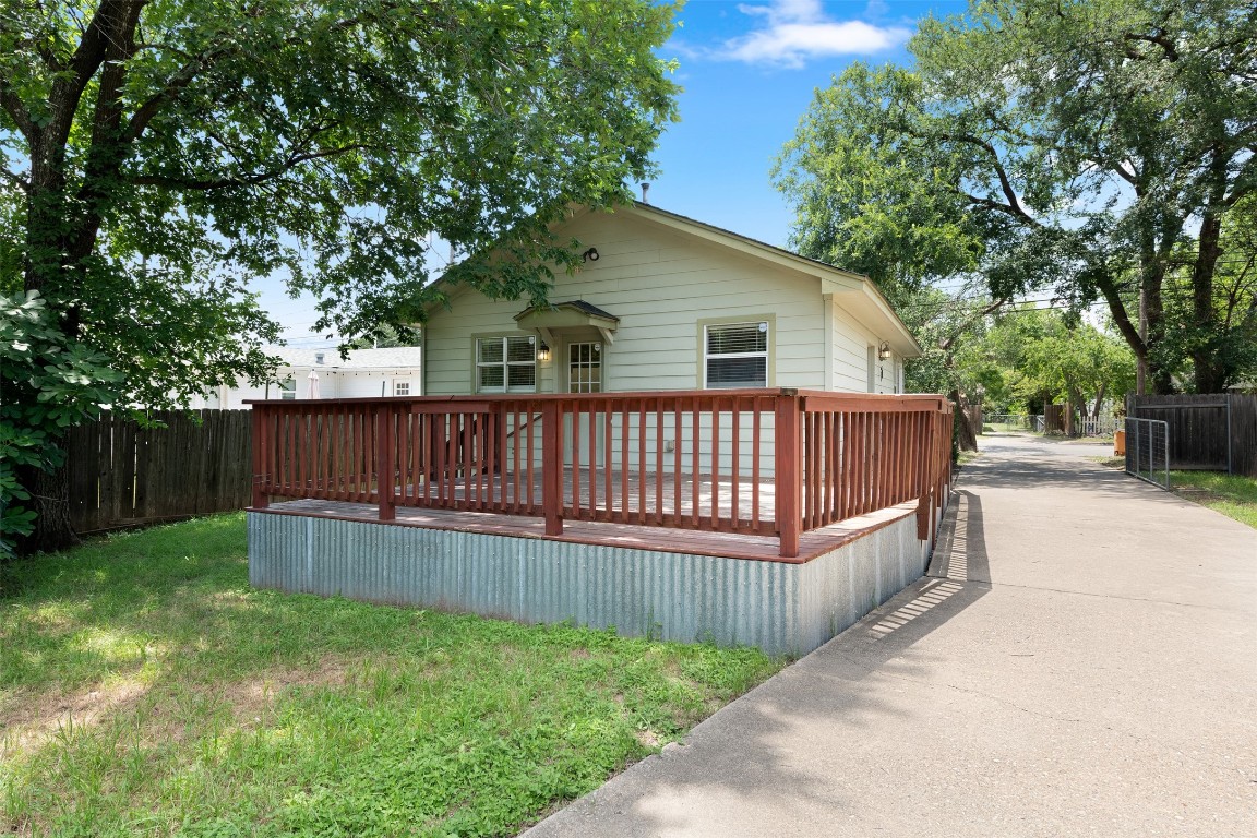 a view of a house with a wooden deck and a large tree