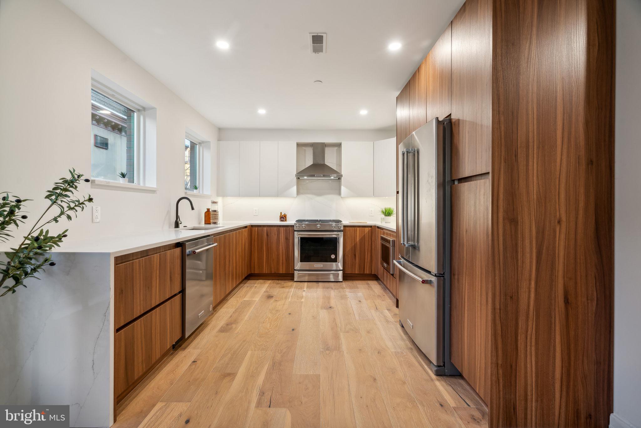 a large kitchen with a large counter top stainless steel appliances and cabinets