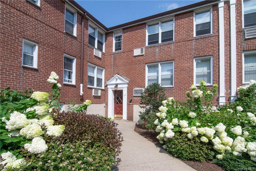 a front view of a house with a bunch of flowers