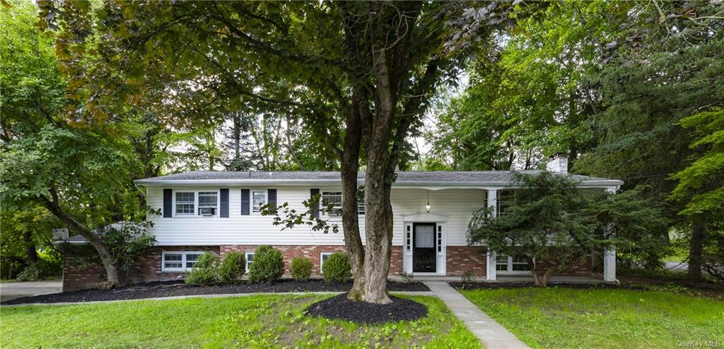 Split foyer home featuring a porch and a front yard