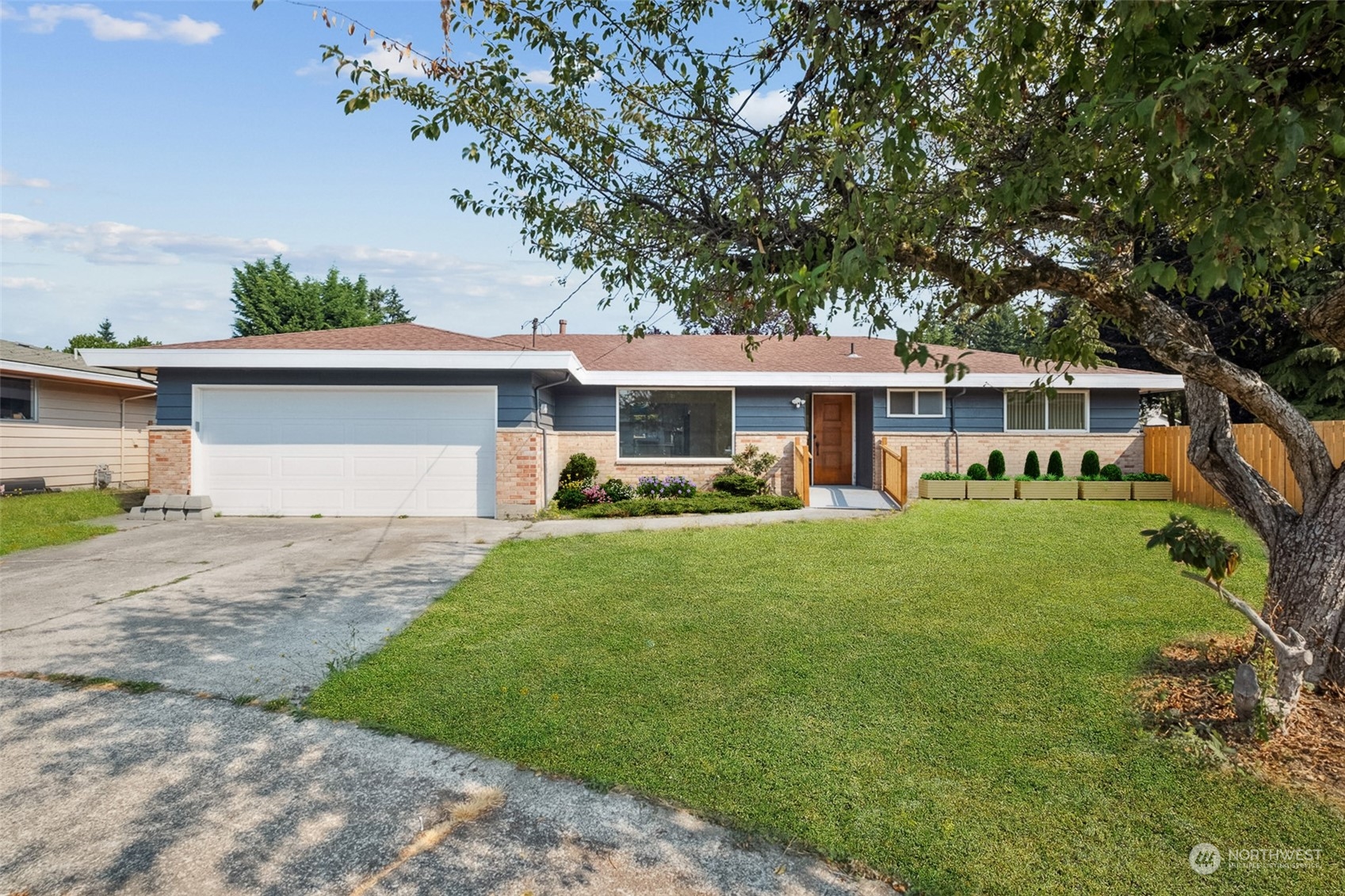 a front view of a house with a yard and trees