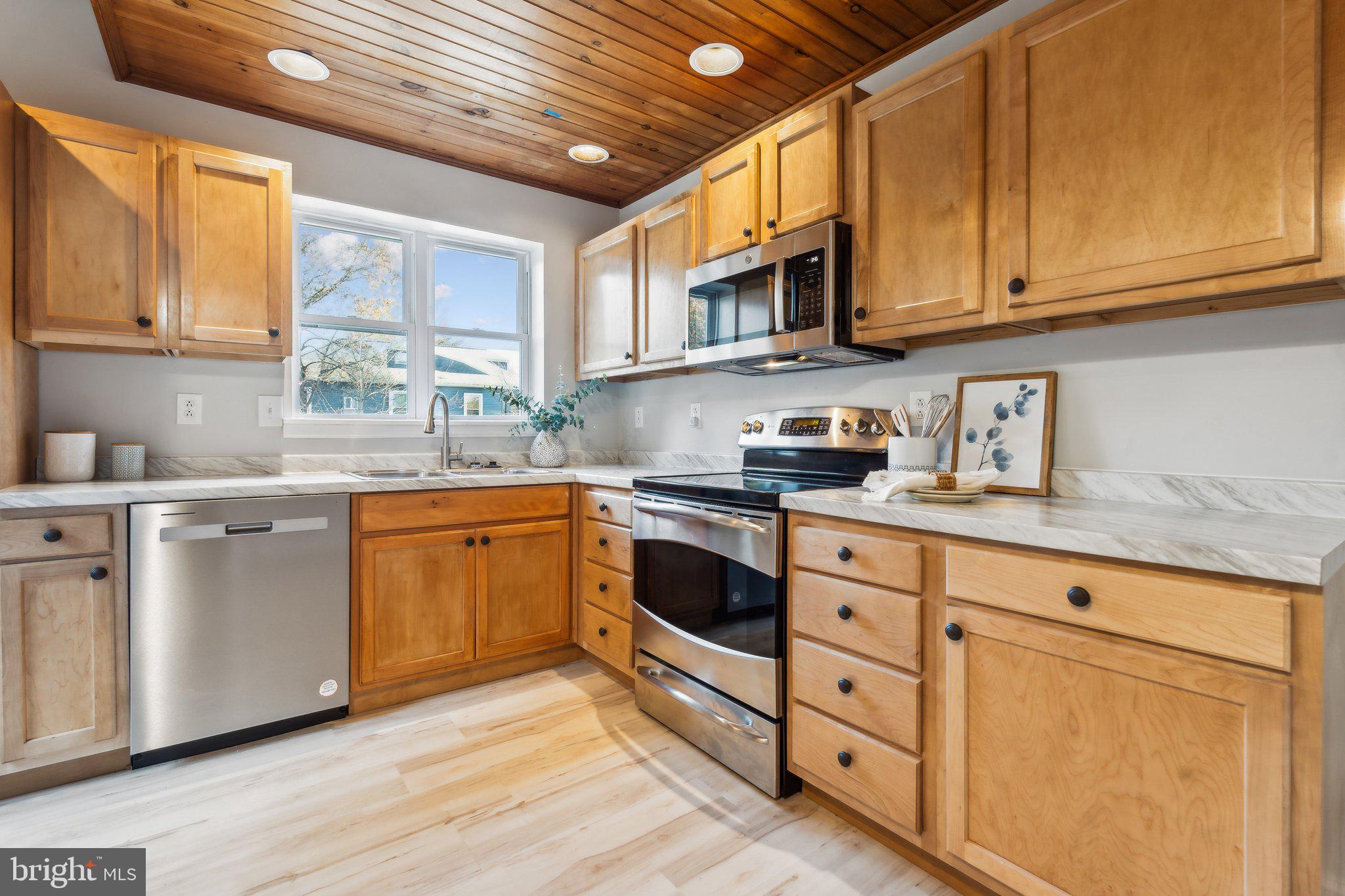 a kitchen with stainless steel appliances granite countertop a sink a stove a microwave and cabinets